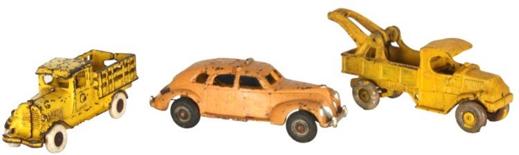 3 Cast Iron Toys: 3 Cast Iron Toys. Attr: Hubley cast iron pick-up truck in nice yellow paint with rubber wheels, 7 in. long. Champion Hardware cast iron tow truck, repainted yellow with rubber wheels, 8.25 in. long. S
