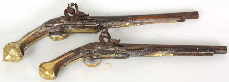2 Antique Turkish Style Flint Lock Pistols: 2 Antique Turkish Style Flint Lock Pistols. Brass mounted pistol with full stock, brass and silver mounts, proof marks at the breach, has breaks and losses to the wood and mounts, missing ram rod; 17.