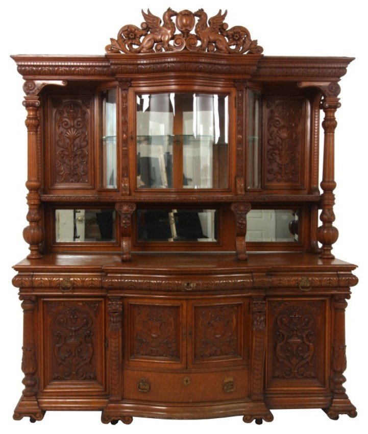 Massive Horner Oak Curio Sideboard: Massive R.J. Horner Lion Carved Oak Curio Sideboard. Large pierced carved crest with figural winged griffins, medallion center and filigree; the top has a single door beveled serpentine front glass cr