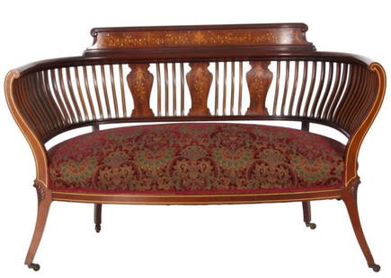 Inlaid Mahogany Settee: Inlaid Mahogany Settee. Elongated bowed back with continuous even arms, carved crest has swirling filigree and inlays with mother of pearl highlights, serpentine spindled back has single band inlays