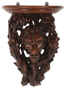 Figural Lion Carved Walnut Wall Bracket: Figural Lion Carved Walnut Wall Bracket. Figural lions mask carved wall bracket with lions face surrounded by pierced carved branches and filigree under a curved front shelf; singed on the top “J &