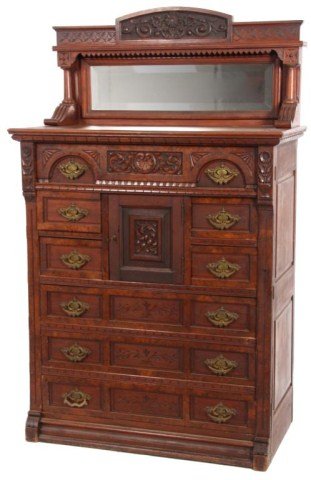 Carved Walnut Eastlake Lockside Chest: Carved Walnut Eastlake Lockside Chest. Has a carved gallery top with a shelf over a beveled mirror; a full length drawer with deep carved center panel having a seashell and swirling leaf design, inset