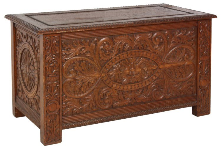 Carved Oak Lift Top Blanket Chest: Carved Oak Lift Top Blanket Chest. Has a hinged lift top with gadroon carved edge, heavily carved inset front panel with relief swirling filigree around a mythical face and carved side panels. In good