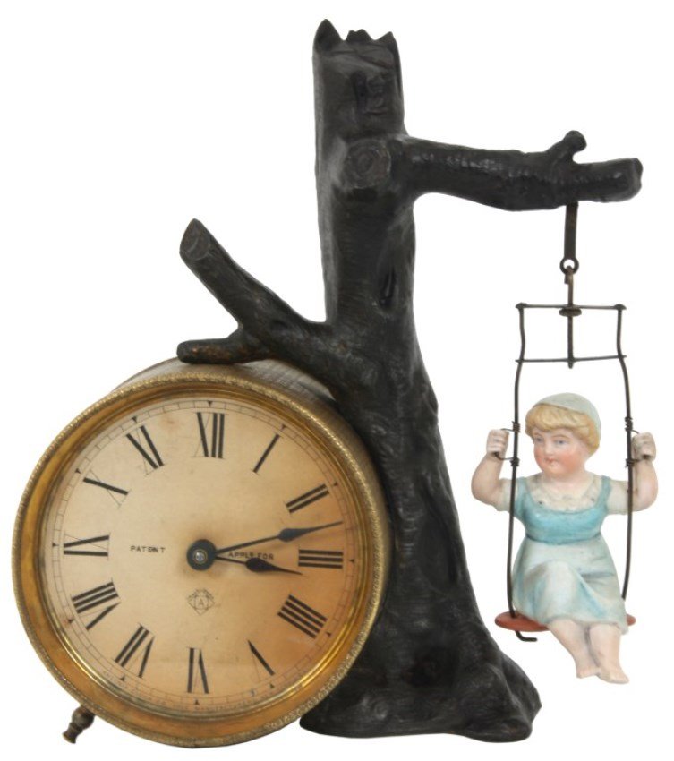 Ansonia No.2 Swinging Doll Clock: Ansonia No.2 Swinging Doll Clock. 3 in. bisque figure of a child seated on a swing acts as the pendulum bob for this clock; the swing hangs from the branch of a tree trunk, cast in white metal. 4 in.