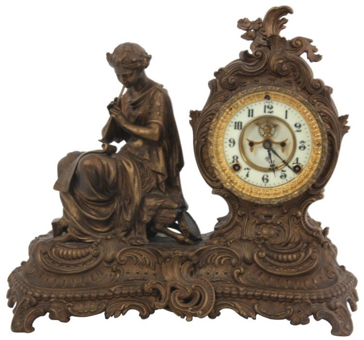 Ansonia Figural Mantle Clock – Fantasy: Ansonia Figural Mantle Clock – Fantasy. French rococo style filigree decorated case has a gilt-brown finish, seated figure of a robed woman on a bench is playing a flute with sheet music in her lap 
