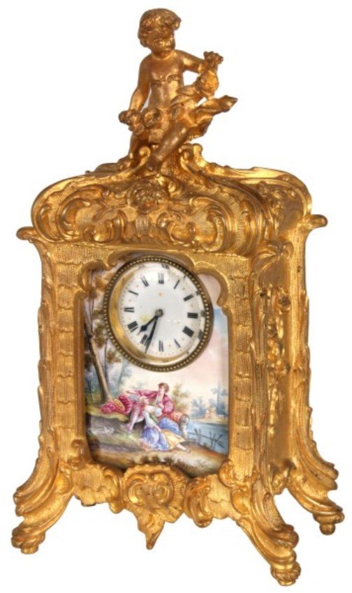 Porcelain & Bronze Clock: Porcelain & Bronze Clock. Beautiful dore bronze case with a figural seated putti finial at the top; has an inset porcelain front panel with a scenic view of a man and woman seated by a lake. 1.5 in. p