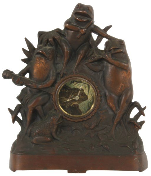 Cast Iron Figural Frog Mantle Clock: Cast Iron Figural Frog Mantle Clock. Iron front case with a patinated copper toned finish, 3 frogs seated in the reeds playing instruments, the head of the banjo represents the bezel of the clock, has