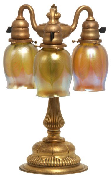 Tiffany Bronze 3 Light Newel Post Lamp: Tiffany Bronze 3 Light Newel Post Lamp. Bronze gold dore base has a round foot with 8 leaves decorating the platform and ribs running from the base through the stem; the top cluster with leafy turned 