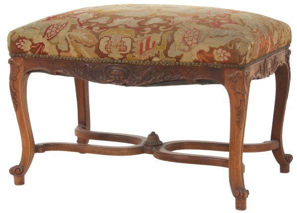 Carved Walnut Needlepoint Foot Stool: Carved Walnut Needlepoint Foot Stool. Figural needlepoint seat with a standing French woman in the center surrounded by filigree; carved filigree on the apron and cabriole legs with scroll feet and fa