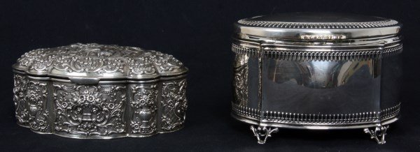 2 Sterling Silver Covered Boxes: 2 Sterling Silver Covered Boxes. 1) Repousse sterling silver box with hinged lid, decorated on the lid with a festive figural and scenic panel with woman & men and on the sides with urns & filigree, g