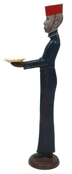 Cast Iron Butler Business Card Tray: Cast Iron Butler Business Card Tray. Tall standing figure of a black butler holding a 5.25 in. dia. tray out in his hands; repainted with a blue uniform with red stripes and red cap. In very good cond