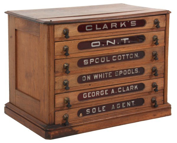 Clarks Walnut Ruby Drawer Spool Cabinet: Clarks Walnut Ruby Drawer Spool Cabinet. Walnut case has inset paneled sides with stenciled trade mark logo on the front for Clark’s O.N.T. (Our Newest Thread) Spool Cotton; has 6 drawers with ruby 