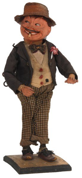 Standing Figural Hobo Automaton: Standing Figural Hobo Automaton. Standing figure of a man with composite head, hands and body wears checkered trousers, straw hat with vest, bow tie and flower pinned to his sport coat; the wind up sp