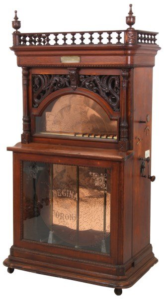 Regina 27 In. Automatic Changer Music Box: Regina 27 in. Automatic 12 Disc Changer Music Box. Automatic style 8 upright 12 disc changing music box is spring driven, plays 27 in. discs on a duplex comb with damper pad on the lower comb, has an 