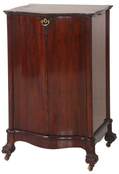 Herzog 2 Door Victrola Music Cabinet: Herzog Mahogany 2 Door Victrola Music Cabinet. 2 serpentine front doors with brass pull, carved overlap molding and escutcheon, stands on unusual ball & claw feet, 8 in. wide slide out work surface on