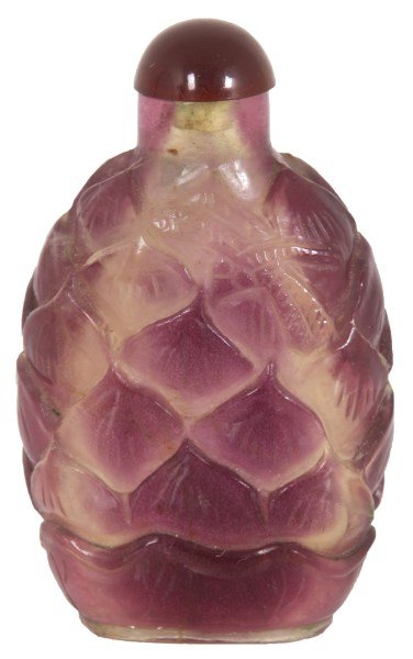 Peking Glass Artichoke Snuff Bottle: Peking Glass Artichoke Snuff Bottle. Purple & clear Peking glass bottle has an ovoid form with relief layered artichoke design, domed lid with stopper; signed on the bottom. 3.25 in. high. Weight: 0.3