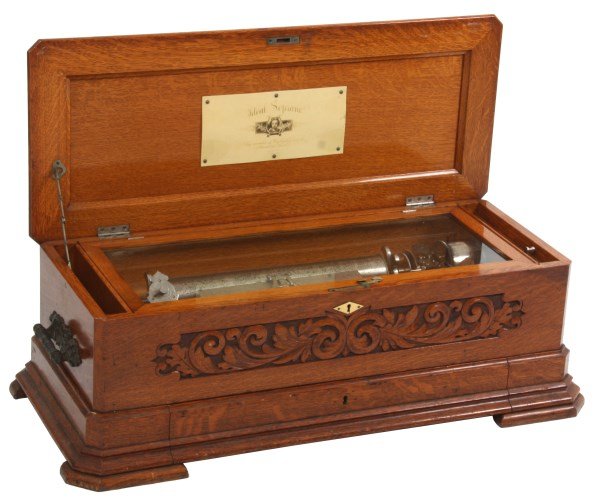 Oak “Ideal Soprano” Cylinder Music Box: Oak “Ideal Soprano” Cylinder Music Box. Oak Model 512 cylinder music box by Mermod Freres of St. Croix, Switzerland case has a filigree carved front panel and drawer in the base holding 3 extra cy