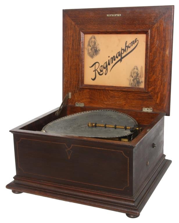 Reginaphone Table Model Music Box: Reginaphone Table Model Music Box. Similar to the Regina style 51 disc music box, this model has an oak case with hinged lid and beaded trim on the top, "Reginaphone" lithograph under the lid, long ir