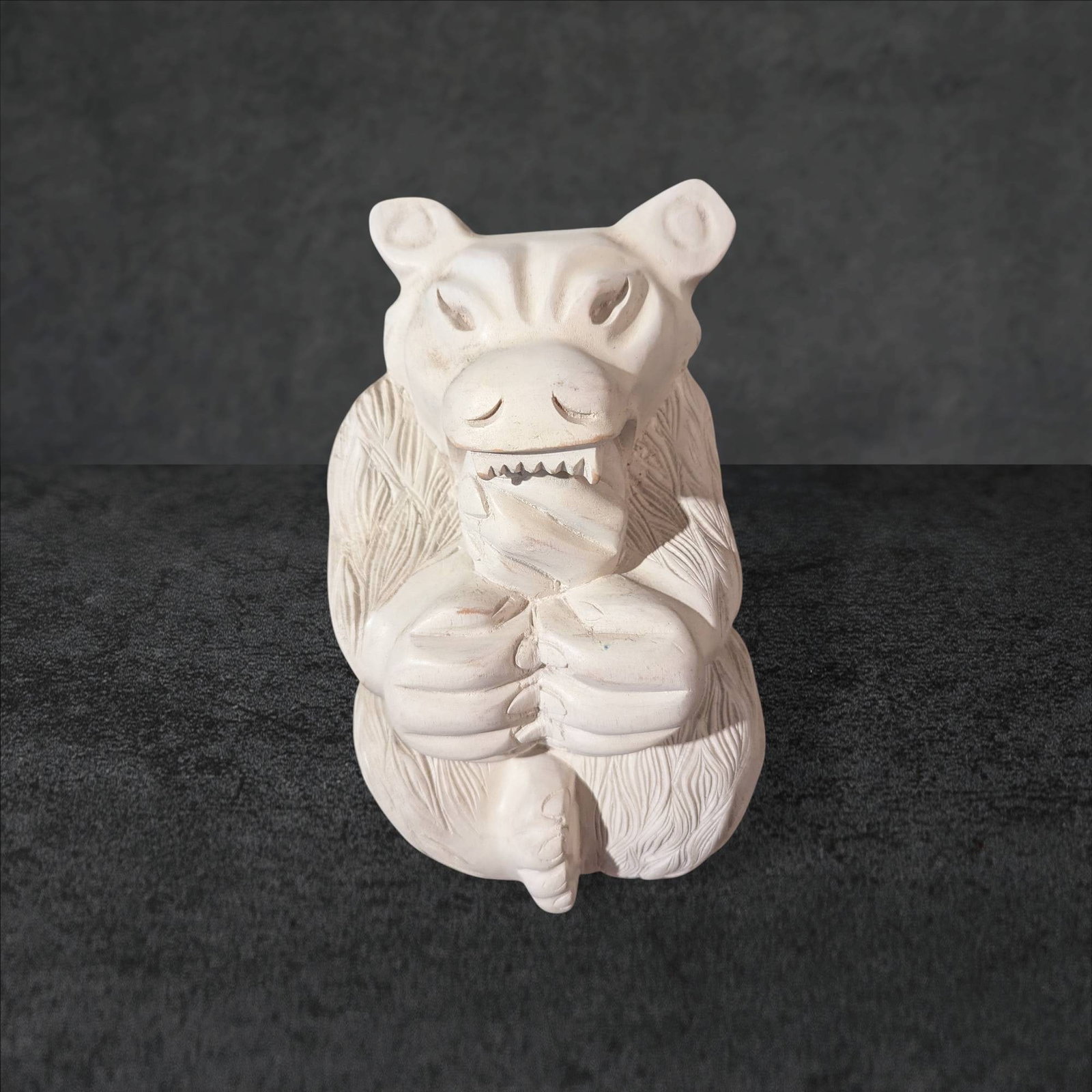 Wooden Carved Asian Bear Sculpture, 11.5 Inches: Hand-carved wooden sculpture of a bear, measuring 11.5 inches in height. The piece depicts intricate detailing of fur, facial features, and the bear holding an object in its paws. The underside bears 