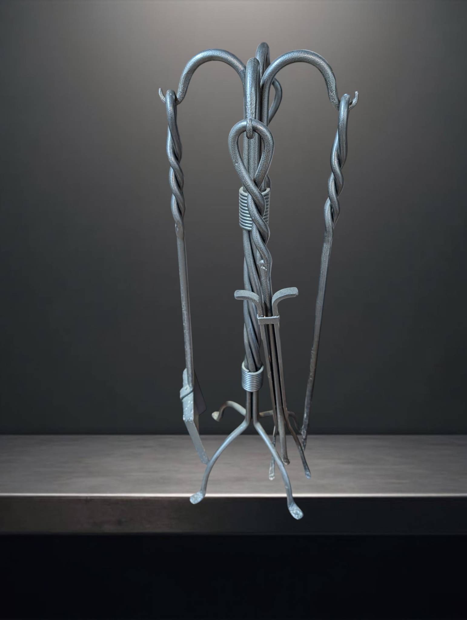 Wrought Iron Fireplace Tool Set With Stand, 32 In Tall: A wrought iron fireplace tool set featuring a twisted metal stand measuring 32 inches in height. Includes four tools: a broom, poker, tongs, and shovel, each designed with looped handles for hanging. 