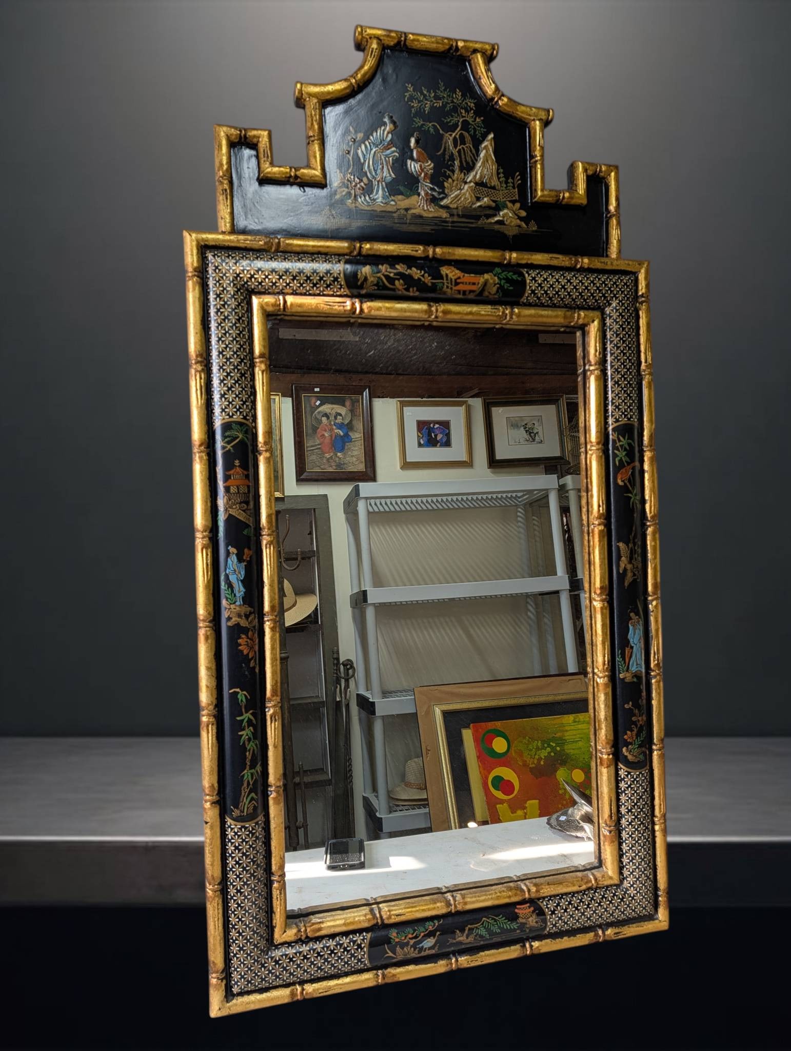 Asian Black Lacquer and Gold Mirror with Bamboo-Style Frame and Asian Motifs: A mid-century Asian black lacquer mirror measuring approximately 55 x 28 inches, featuring a gold leaf bamboo-style frame. Adorned with hand-painted Asian motifs, including figures, landscapes, and de