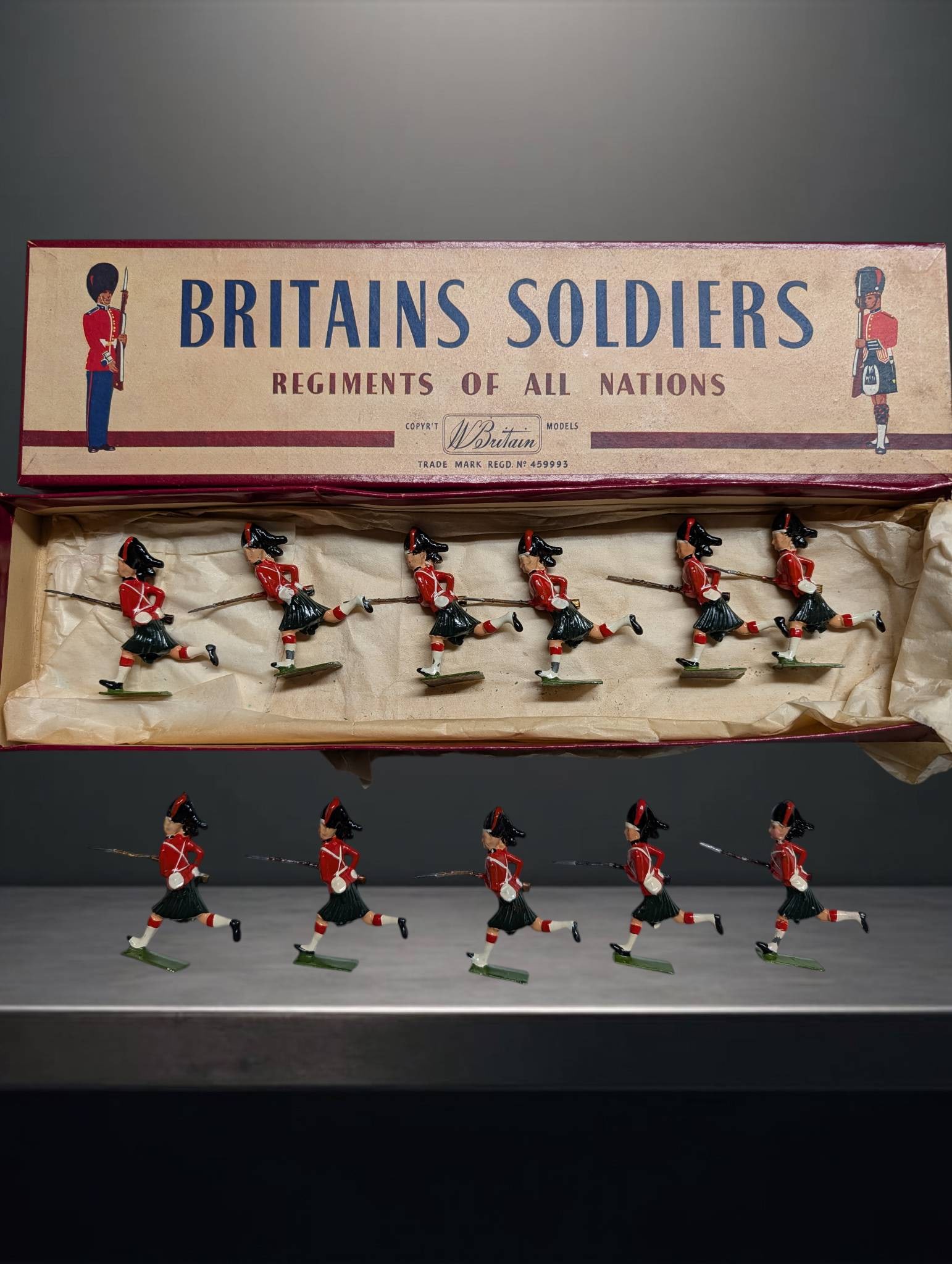 Britains Soldiers Regiments of All Nations Boxed Set with Eight Running Highland Infantry Figures: Eight painted metal figurines representing Highland infantry soldiers in running poses, approximately 2 1/2 inches tall. Includes original box marked 'Britains Soldiers, Regiments of All Nations,' wit