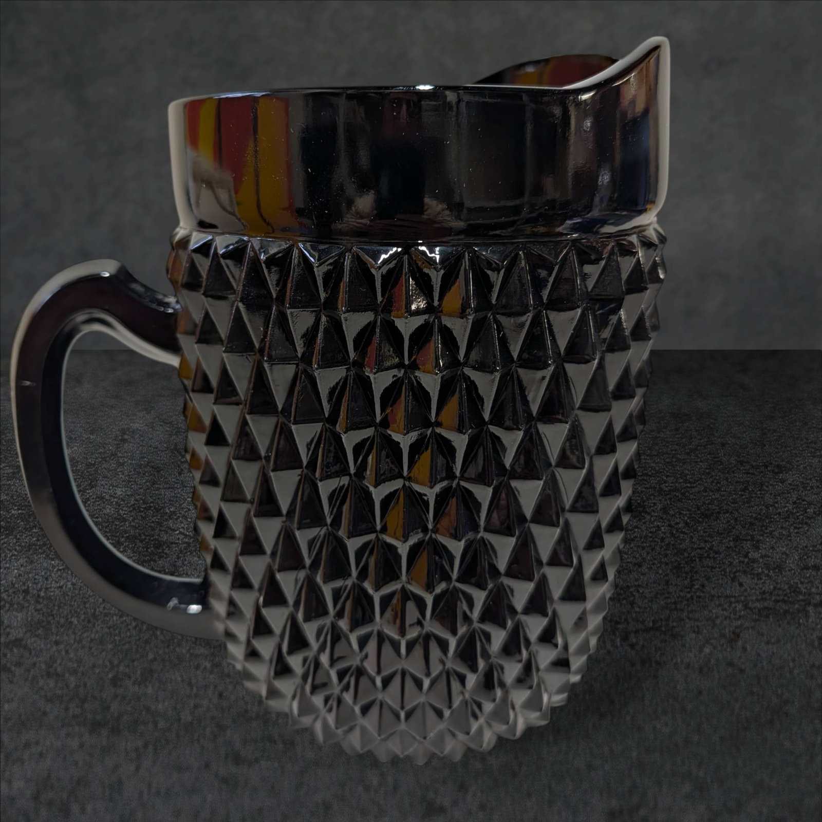 Vintage Black Diamond Point Tea Pitcher by Tiara Indiana Glass, 8 1/4 in Tall: Vintage black glass tea pitcher manufactured by Tiara Indiana Glass in the Diamond Point pattern. Measures 8 1/4 inches tall and 5 1/4 inches in diameter. Features a textured diamond-point pattern, a 