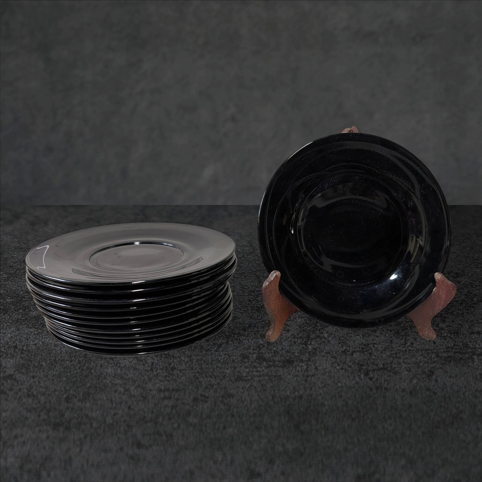 12 Black Amethyst Glass Salad Plates, 7.5 Inch Diameter: 12 black amethyst glass salad plates, each with a diameter of 7.5 inches. The plates display a rich, dark appearance typical of black amethyst glass, which exhibits subtle purple tones when held to li