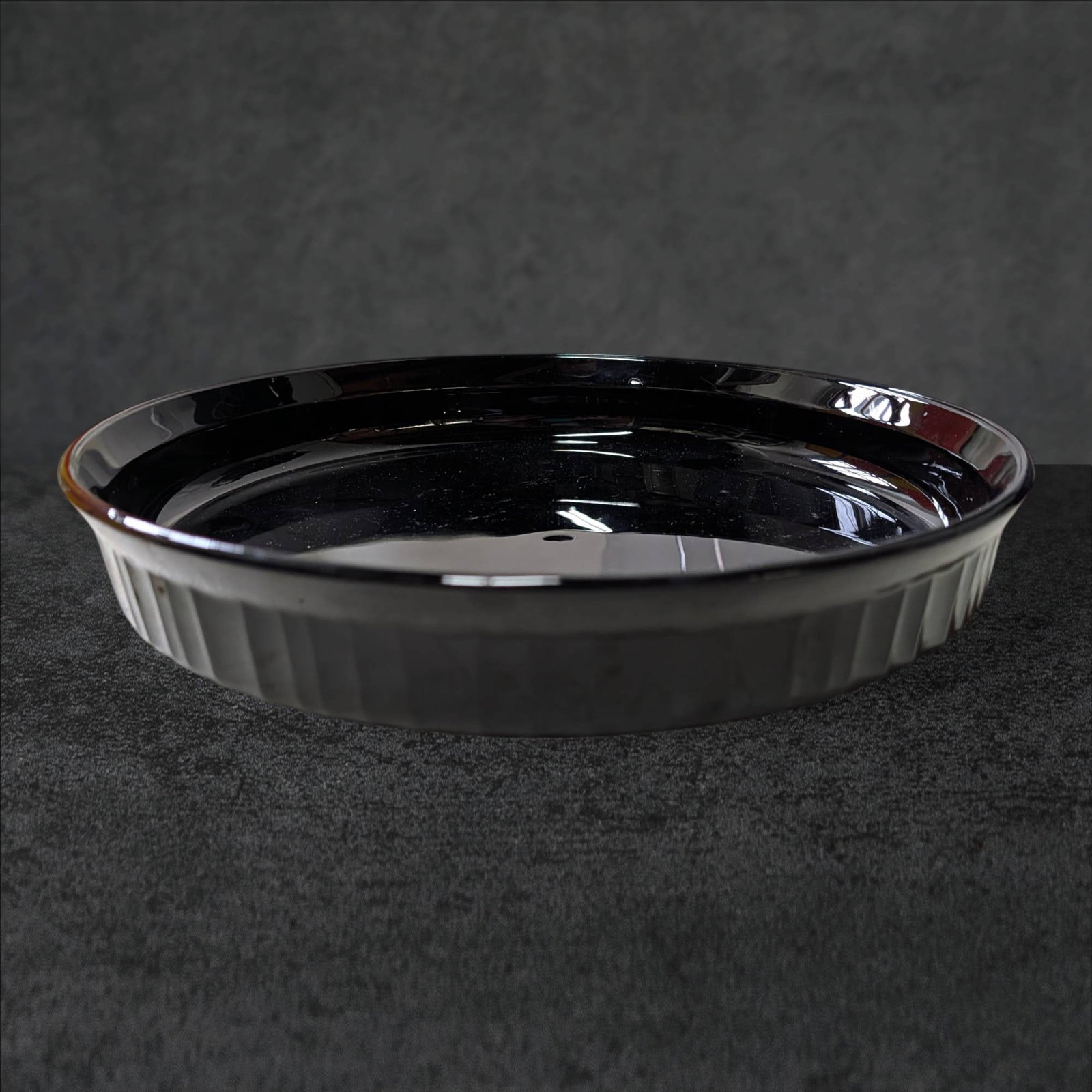 Black Amethyst Glass Plate, 10.5-Inch Diameter: Round black amethyst glass plate with a diameter of 10.5 inches and a height of 1.5 inches. Features a slightly flared rim with a paneled design on the exterior. The glass exhibits a dark amethyst hue