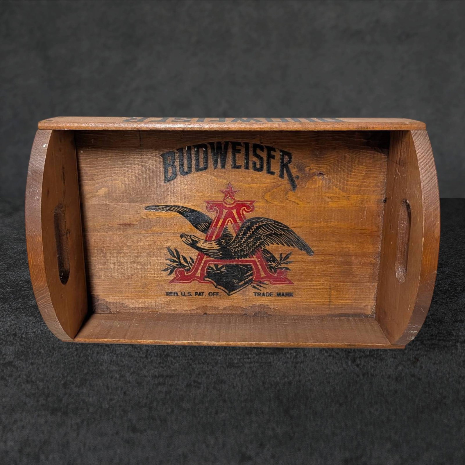 Vintage Budweiser Wooden Serving Tray with Anheuser-Busch Branding: Wooden serving tray featuring Budweiser and Anheuser-Busch branding. Rectangular in shape, measuring approximately 18 in. x 11.5 in. x 6 in., with hand-cut side handles and visible joinery along the e