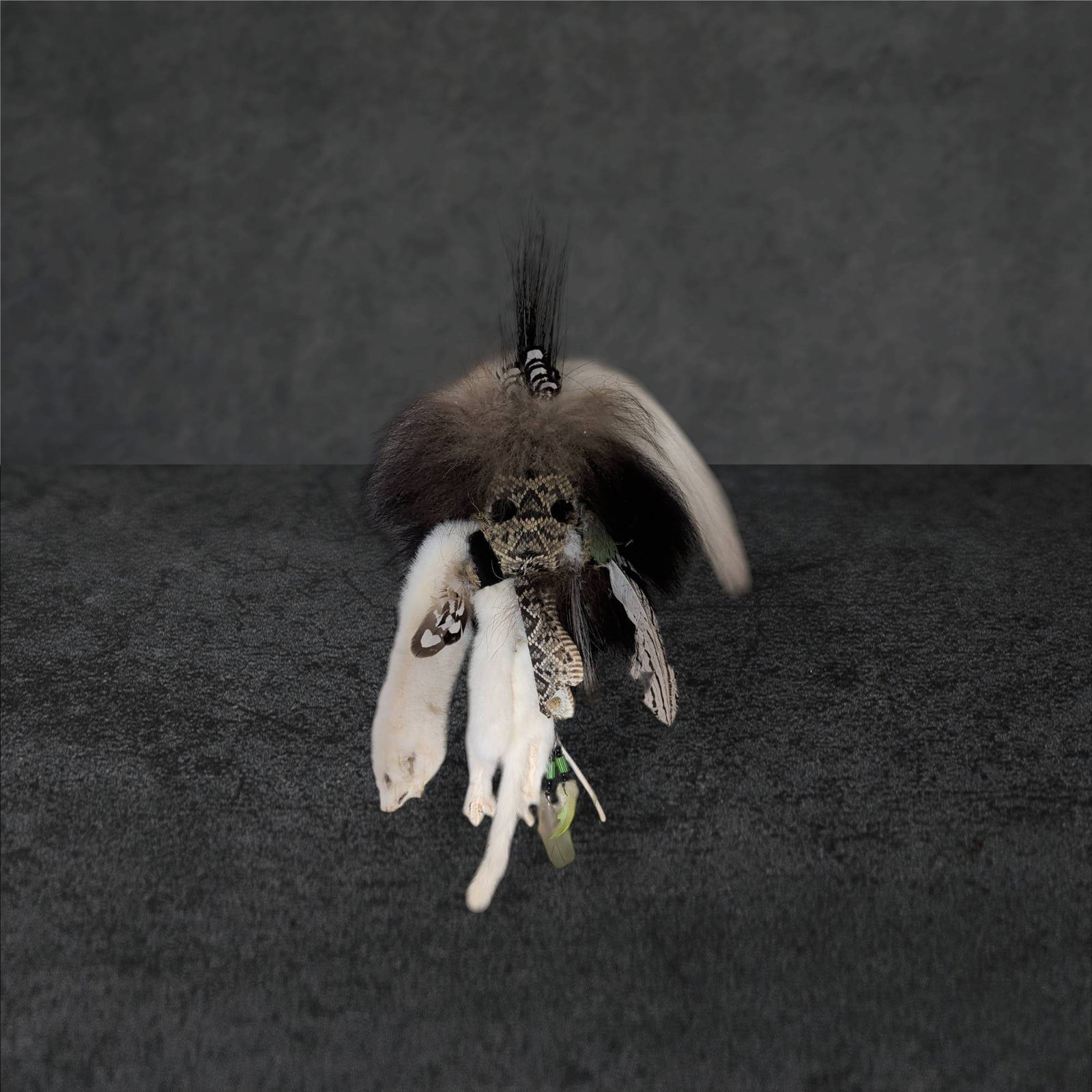Handcrafted Decorative Mask with Snakeskin, Fur, Feathers, and Beads: Decorative handmade mask crafted from natural materials, including a primary snakeskin element, various furs, feathers, and beaded strands. The mask appears to incorporate artistic styles resembling N