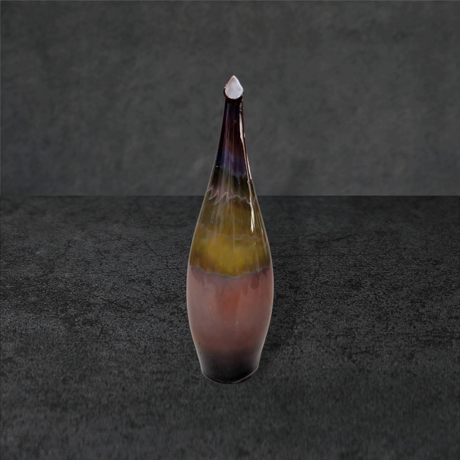 Hand-Blown Multicolor Glass Decorative Vase, Approximately 8 Inches Tall: Hand-blown glass vase featuring a tapering form with a pointed top. The piece displays a gradient of earthy tones, including brown, amber, and hints of purple, with subtle transitions and flowing colo