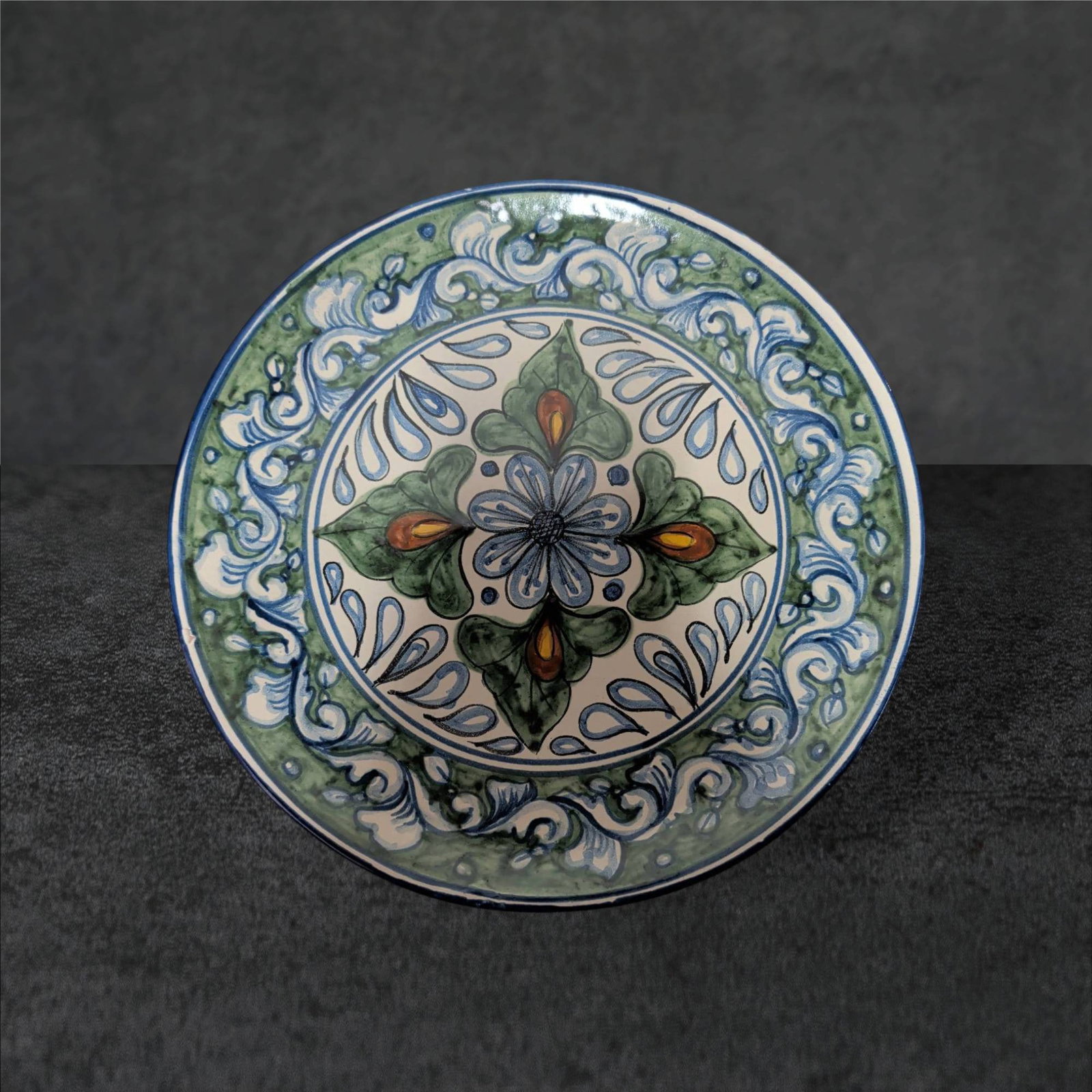 Hand-Painted Decorative Ceramic Platter, 11 1/4 Inches, Signed â€˜M.Z.â€™: Hand-painted ceramic platter featuring a floral and scroll design in green, blue, and orange tones on a white background. Measuring 11 1/4 inches in diameter, the piece is signed 'M.Z.' on the undersi