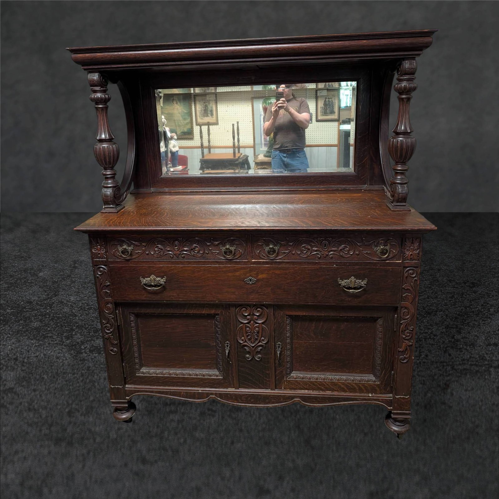 Late 19th-Century Victorian Renaissance Revival Quarter-Sawn Oak Sideboard: Victorian Renaissance Revival sideboard made from quarter-sawn oak, dating between 1880-1900. Features ornate hand carvings, decorative brass hardware, and a beveled mirror supported by carved columns