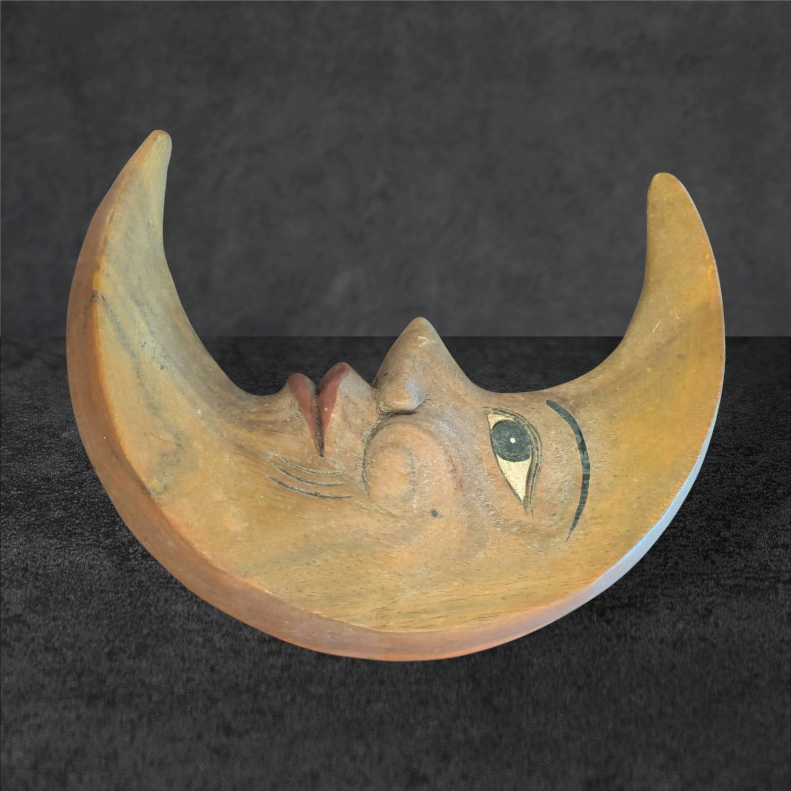 Hand-Carved Wooden Half Moon Face Sculpture, 12 x 8 in.: Hand-carved wooden sculpture depicting a crescent moon with a stylized human face in profile. Measures approximately 12 inches by 8 inches. The front surface is painted with subtle detailing, includin