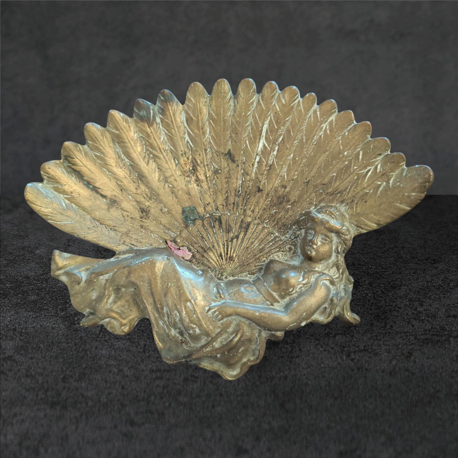 Art Deco Brass Card Dish with Reclining Woman and Fan Motif: An Art Deco-style brass card dish featuring a reclining woman in flowing attire, backed by a detailed fan design. Measures approximately 6 1/2 inches by 5 inches. The cast brass construction exhibits 