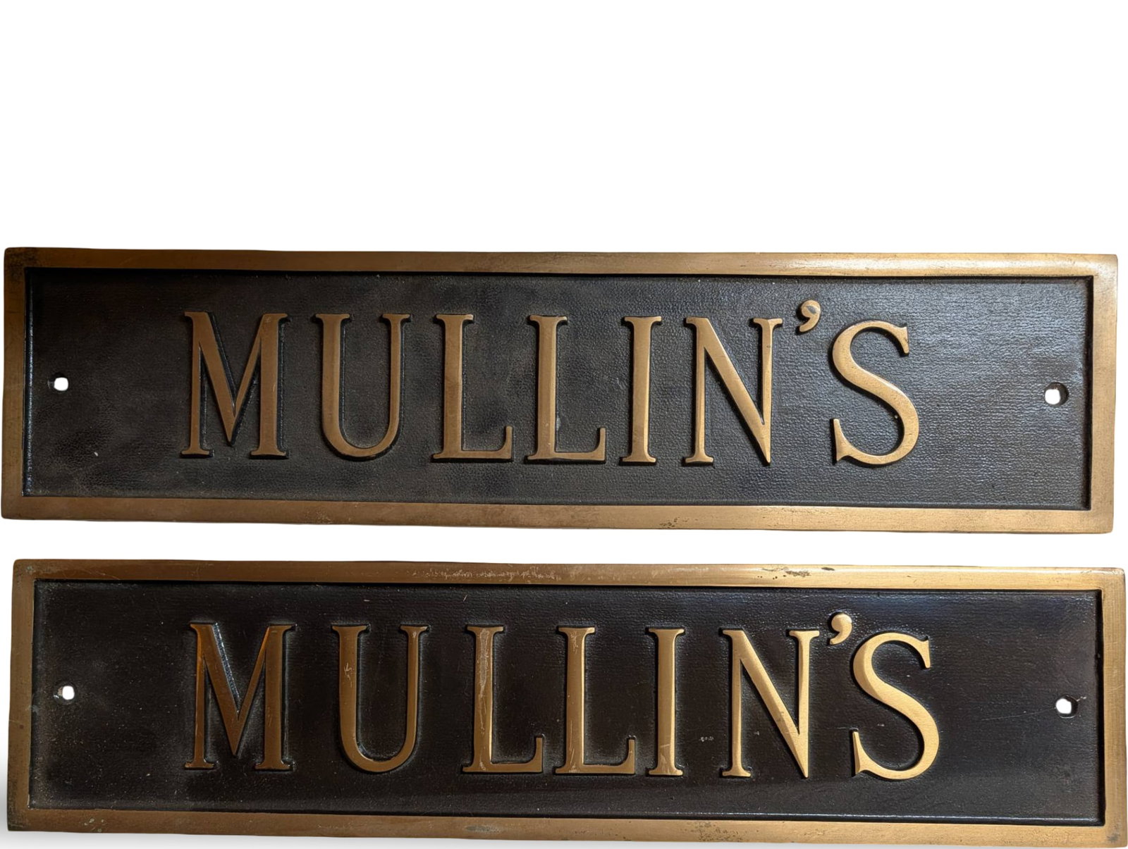 Bronze Signs by J. Ash Matthews & Co., Pittsburgh, PA: Two bronze signs, each measuring 19 1/2 inches by 5 inches, featuring the embossed text 'MULLIN'S.' Manufactured by J. Ash Matthews & Co., Pittsburgh, PA, and marked with 'DL215' on the reverse. Each 