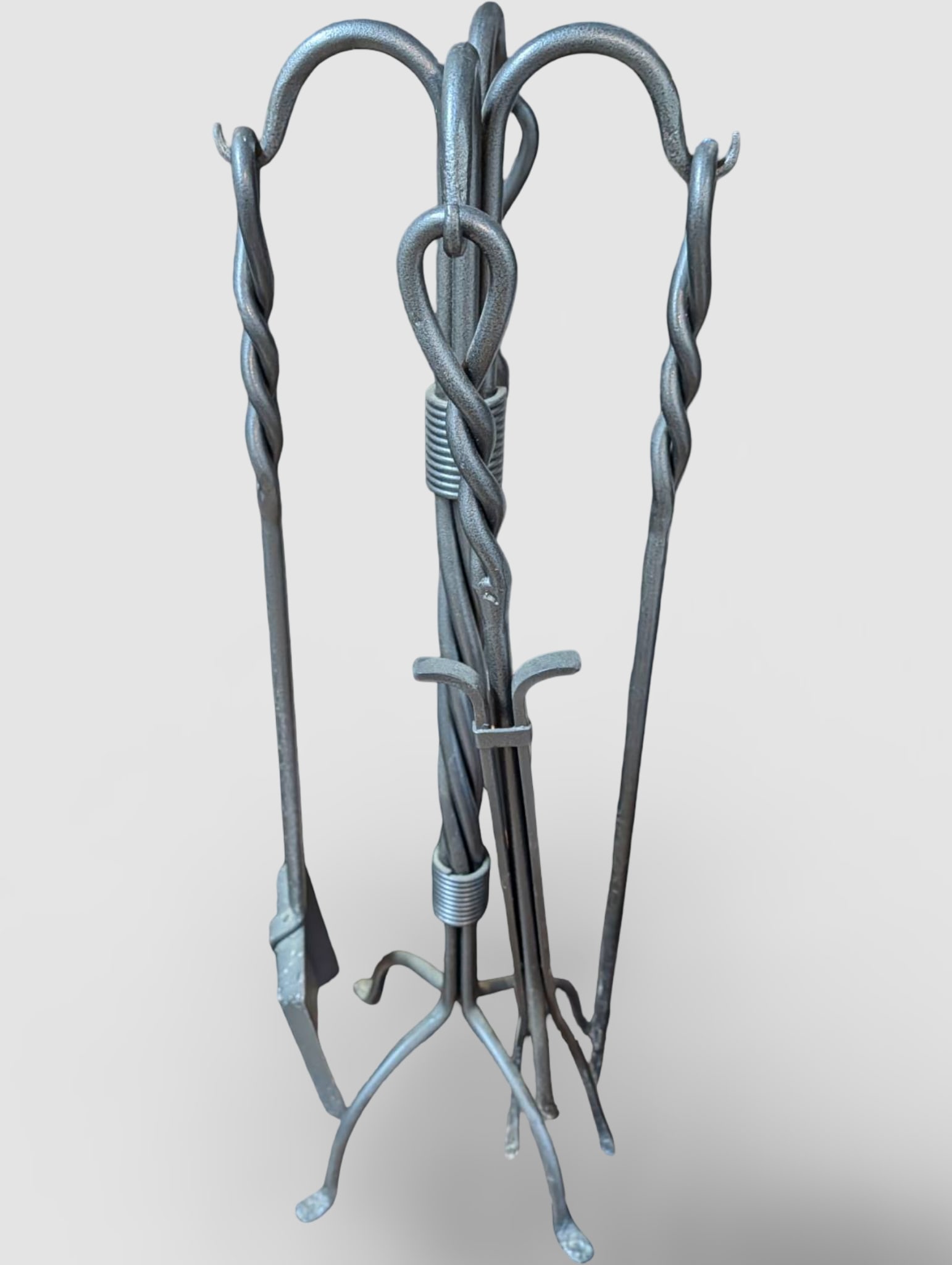 Wrought Iron Fireplace Tool Set With Stand, 32 In Tall: A wrought iron fireplace tool set featuring a twisted metal stand measuring 32 inches in height. Includes four tools: a broom, poker, tongs, and shovel, each designed with looped handles for hanging. 