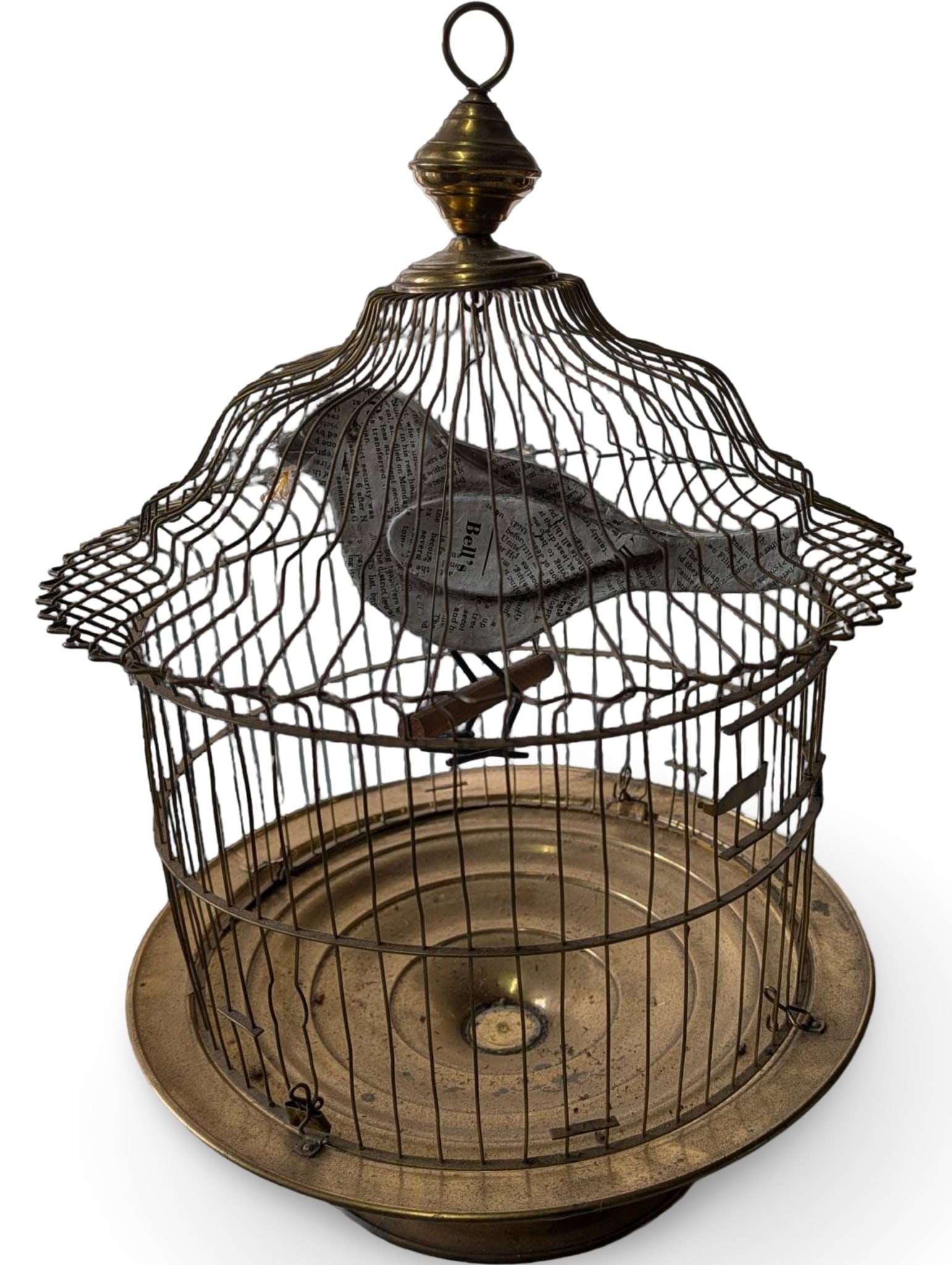 Mid-Century Brass-Toned Bird Cage with Pop Art Newspaper Print Bird: Brass-toned bird cage featuring a curved wire construction and a decorative pop art bird crafted from newspaper print. The cage is topped with a finial and suspension ring and has a circular base tray