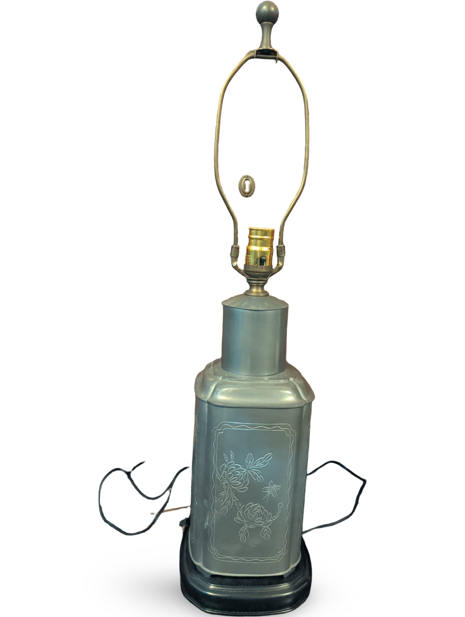 Metal Table Lamp with Floral Engraving, 19 Inches Tall: Metal table lamp measuring 19 inches tall, featuring floral engravings on the rectangular base and set on a black wooden pedestal. The lamp includes a brass socket, harp, and finial for a shade (not i