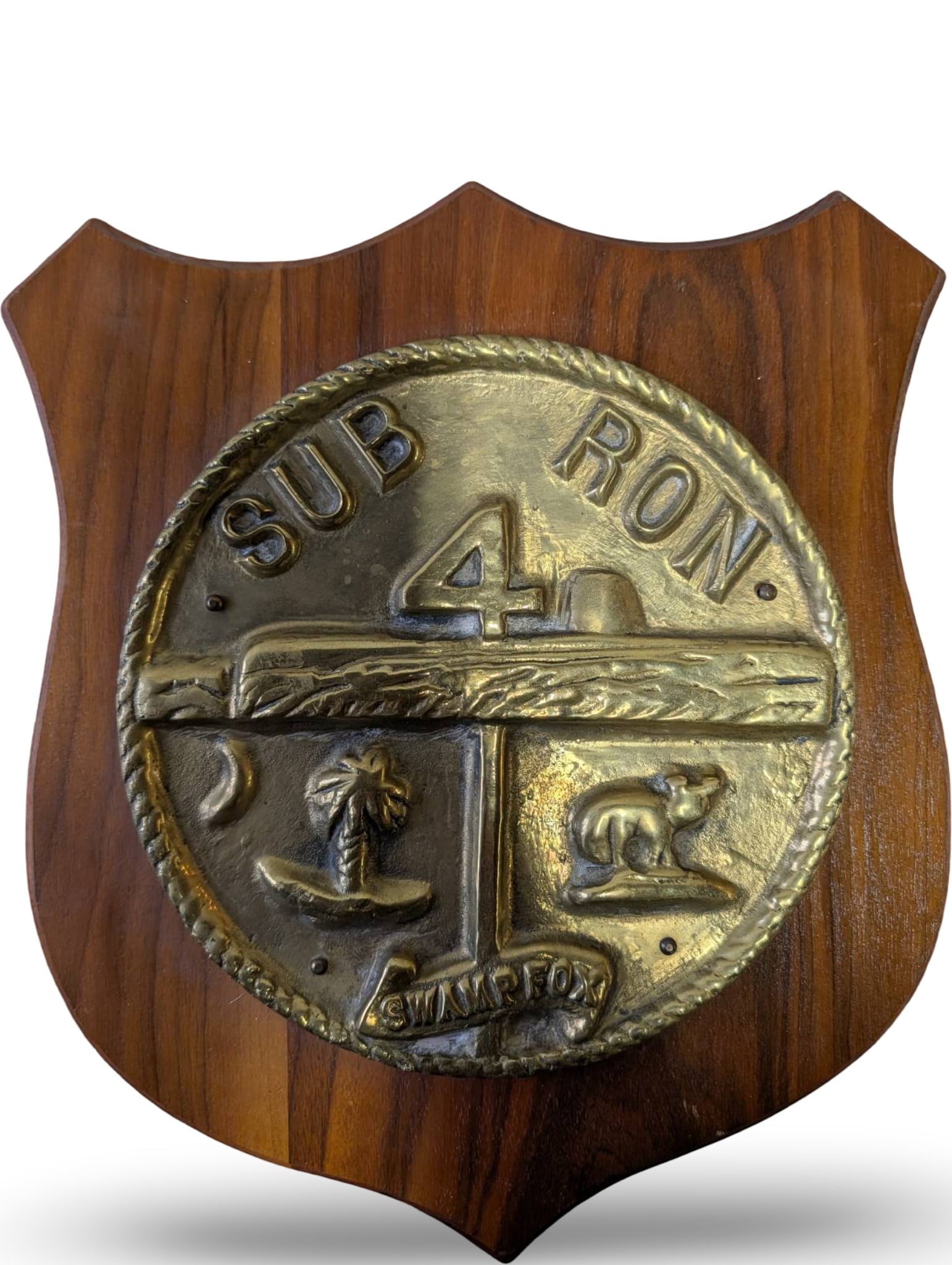 Submarine Squadron 4 Crest Plaque Featuring â€˜Swamp Foxâ€™ Design: Wooden shield-shaped plaque measuring approximately 10 x 12 inches, displaying the metal crest for Submarine Squadron 4 ('Sub Ron 4'). The crest features intricate details, including the 'Swamp Fox' m