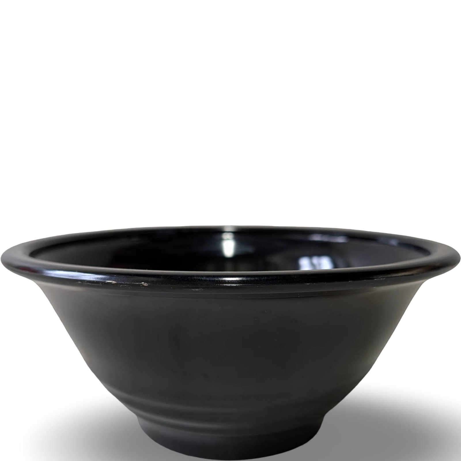 Black Amethyst Glass Bowl, 9.5 Inches in Diameter: Black amethyst glass bowl measuring 9 1/2 inches in diameter and 4 1/4 inches in height. The bowl features a smooth, glossy finish with a subtly flared rim. Its dark hue reveals a purple undertone whe