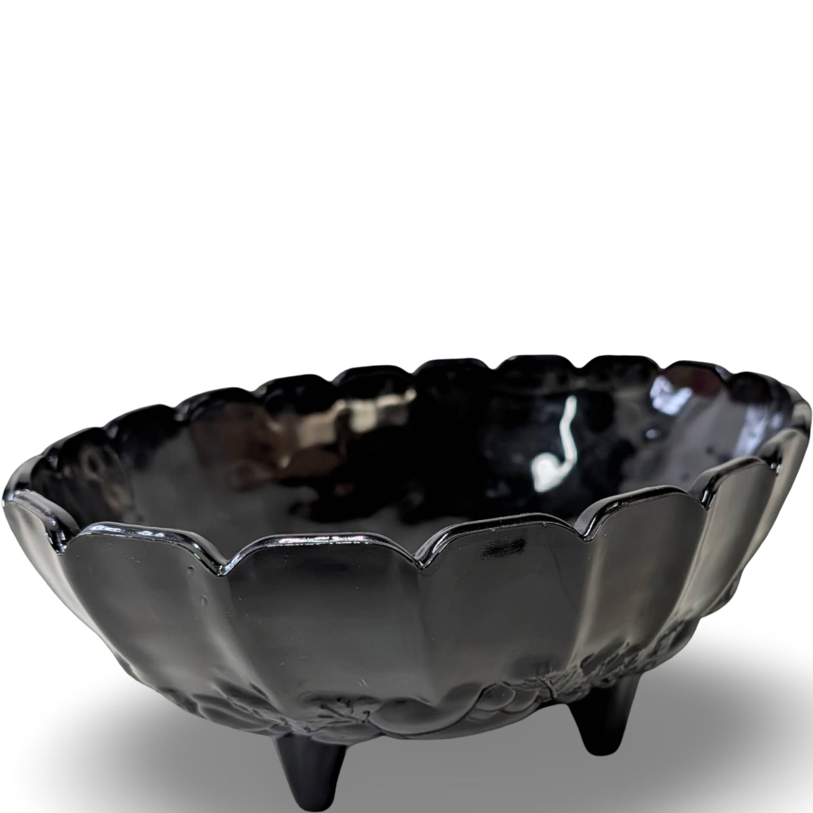 Footed Black Amethyst Glass Bowl, 12 1/4 In. x 8 1/2 In. x 4 1/2 In.: Footed black amethyst glass bowl featuring a scalloped rim and fruit-themed decorative elements. Measures approximately 12 1/4 inches in length, 8 1/2 inches in width, and 4 1/2 inches in height. The 
