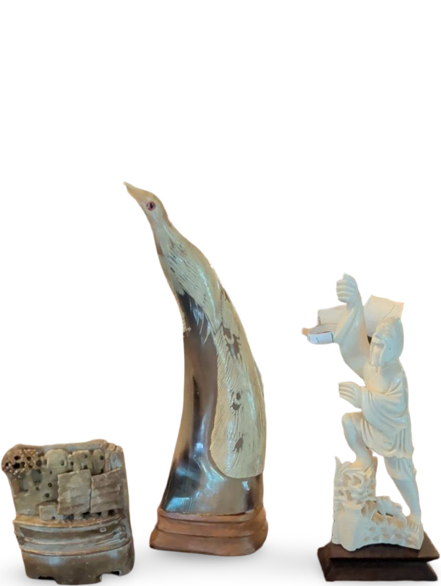 Trio of Decorative Sculptures Including Carved Figurine, Stone Block, and Etched Horn: Three decorative items. Tallest is a 10-inch etched horn sculpture on a wooden base depicting an animal figure. Includes a carved figurine on a square base, likely resin, showcasing a dynamic pose wit