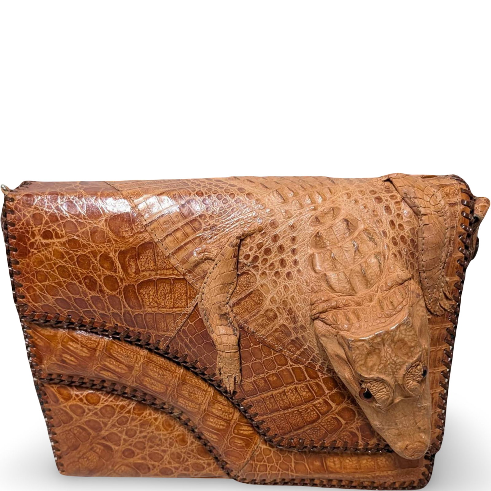 1950s Alligator Purse with Sculpted Design, Made in the USA: A handmade 1950s alligator purse featuring a sculpted alligator detail on the flap. Crafted in the USA, it measures 12 in by 8.5 in by 3 in. The interior has multiple compartments and is lined with a 