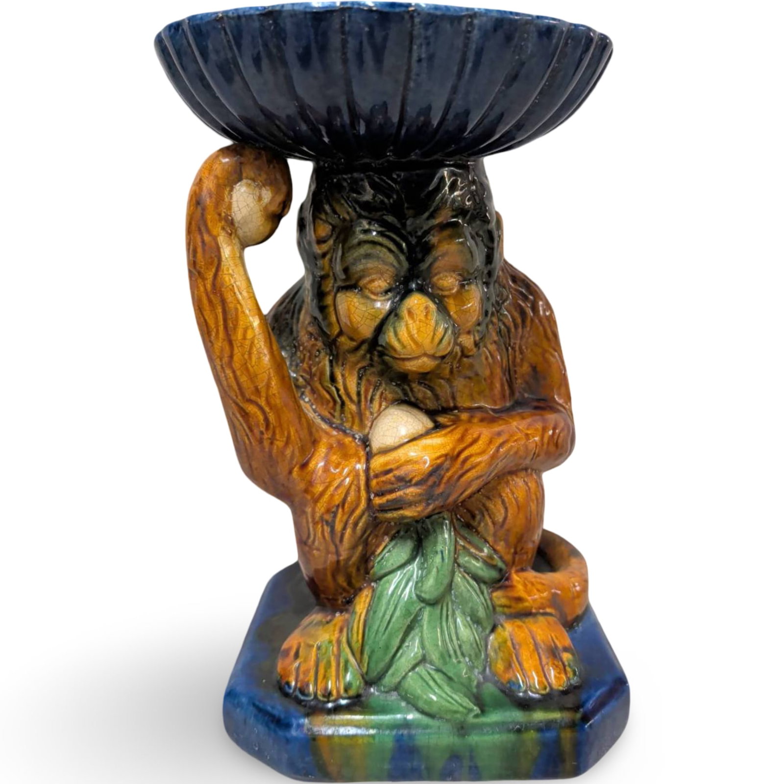 Vintage French Majolica Monkey Plant Holder or Fruit Bowl, 10 x 6 x 6 in.: Vintage French majolica decorative piece featuring a monkey holding up a wide, fluted bowl on its head. Made of glazed ceramic with vibrant hand-painted colors including blue, orange, and green, with 