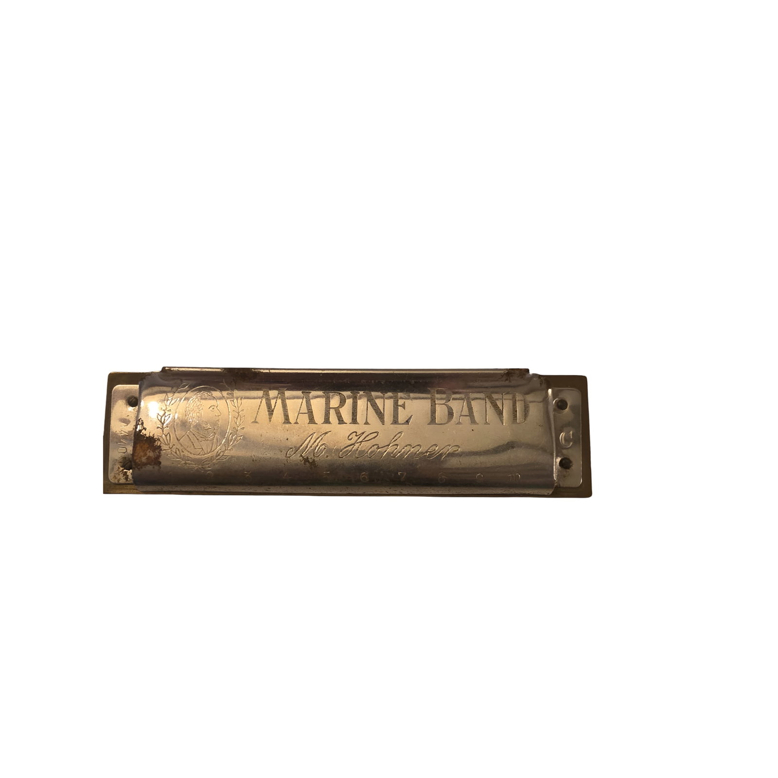 Marine Band Harmonica by M. Hohner, Germany: Marine Band diatonic harmonica manufactured by M. Hohner in Germany. Features engraved metal covers and wooden comb design. Notable wear and patina present on the metal indicating use. Exact key and a