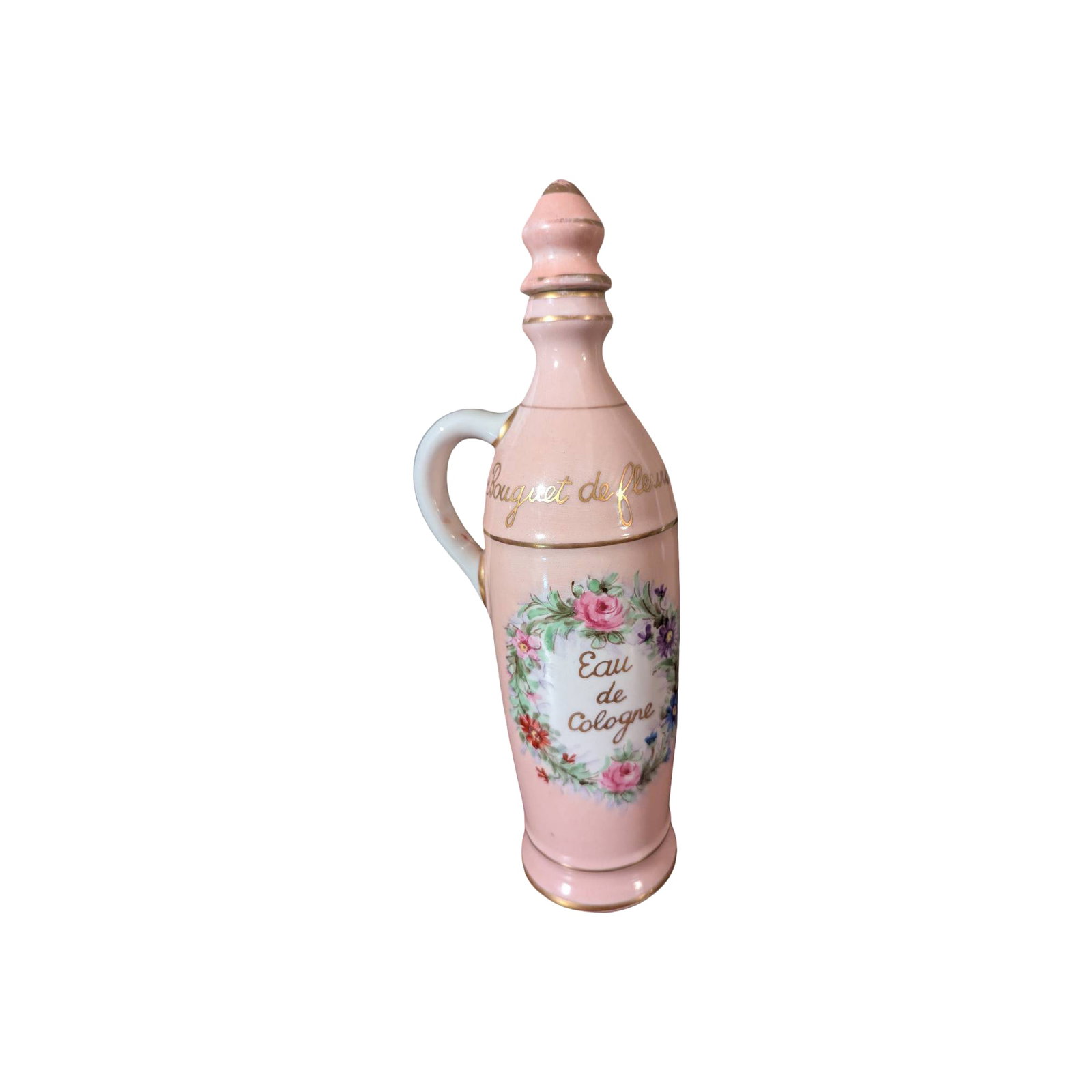 10 1/2 In. Lamoges Hand-Painted Porcelain Cologne Bottles: Porcelain cologne bottles measuring 10 1/2 inches tall, with pink hand-painted exteriors. Each features 'Eau de Cologne' text surrounded by floral garlands and gold-painted accents. Stoppered tops and