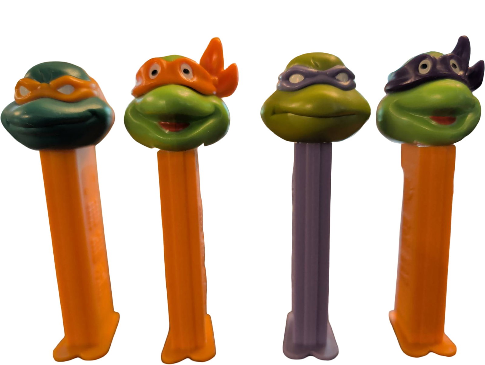 4 Teenage Mutant Ninja Turtles PEZ Dispensers: 4 PEZ candy dispensers featuring the Teenage Mutant Ninja Turtles characters: Leonardo, Michelangelo, Donatello, and Raphael. Each plastic dispenser showcases the corresponding turtle’s head with th