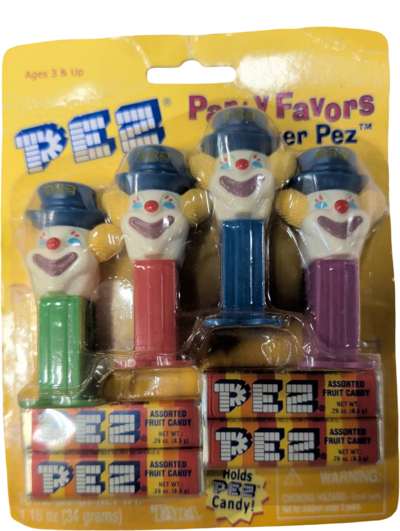 Pack of Four PEZ Clown Candy Dispensers in Original Packaging: Four PEZ candy dispensers featuring clown heads, each with differently colored bases (green, blue, red, and purple). Pack is unopened and retains its original packaging, marked as 'Party Favors.' Incl